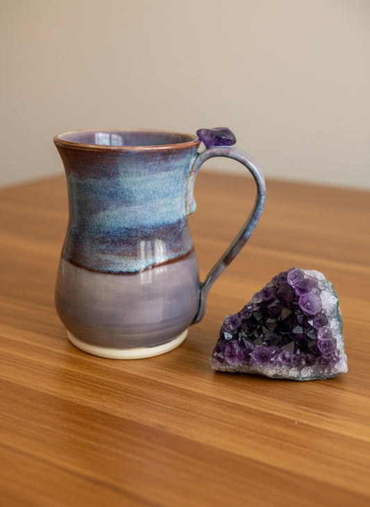 Ceramic mug with purple and blue glaze on a white background