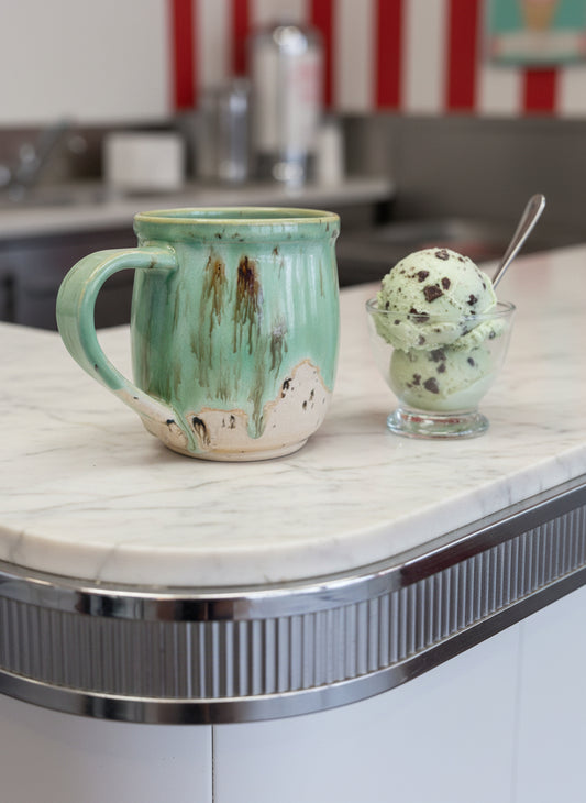 Green ceramic mug with speckled design on a white background